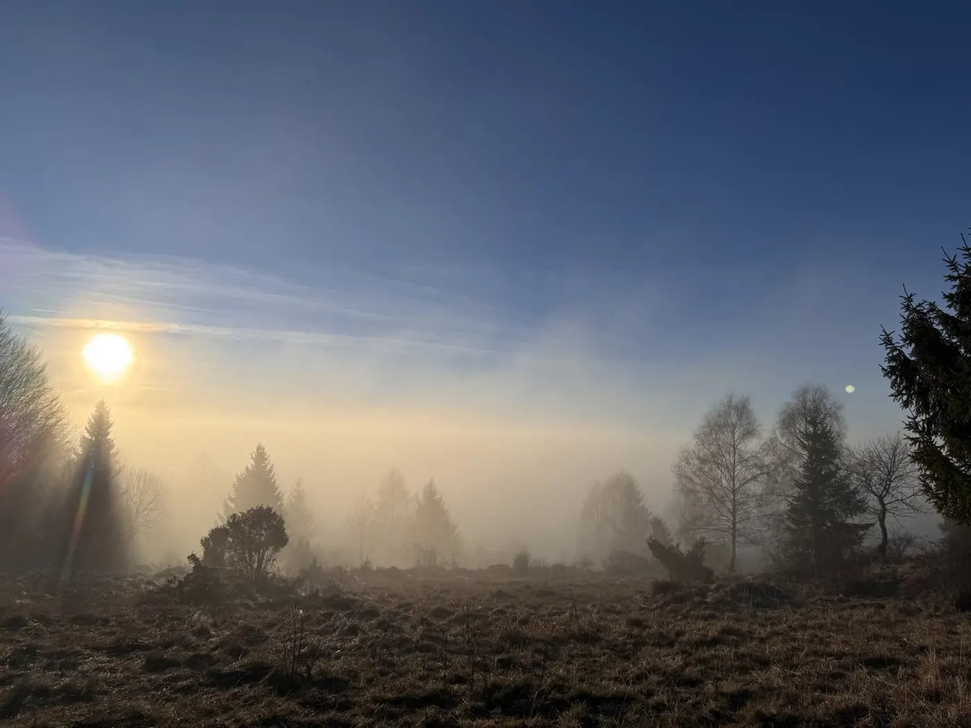 Slnko nad hranou hmly pri západe